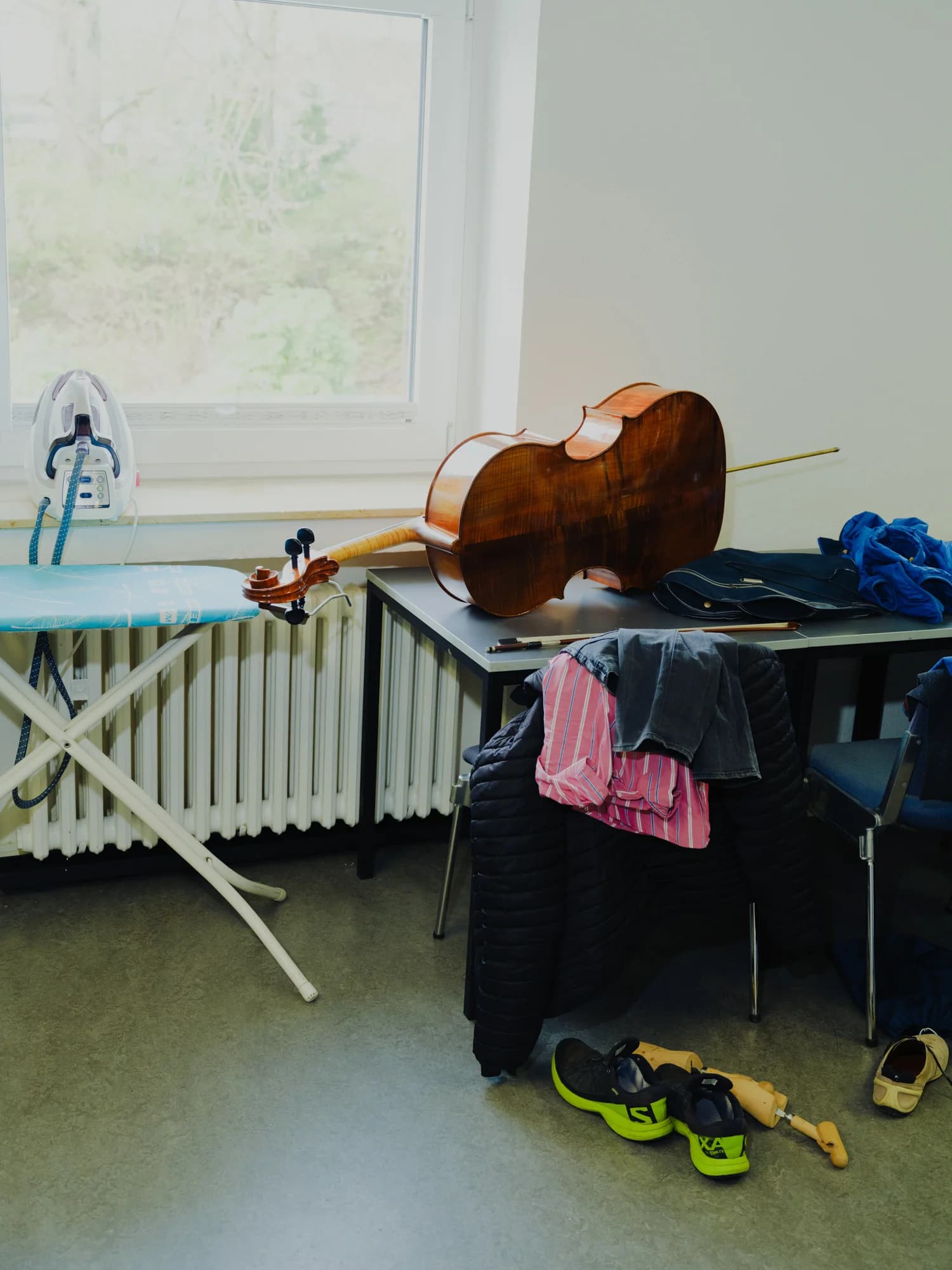 Bügelbrett und Cello mit Turnschuhen